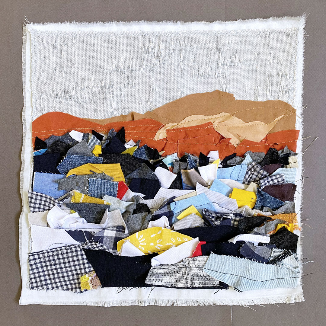 Atacama Desert Clothing Dump - a textile art piece comprised of scraps of clothing depicting a dump of brightly colored textiles in a red desert - by Liz Broekhuyse